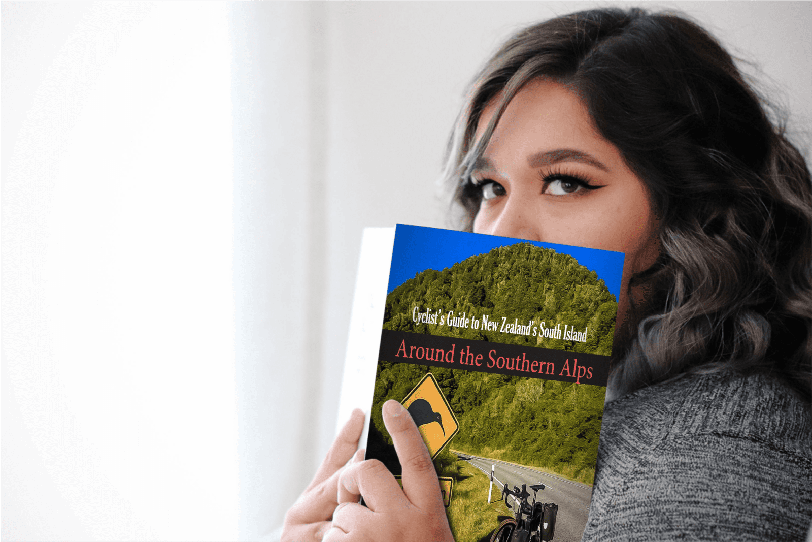 Girl holding Cyclist's Guide to South Island, New Zealand